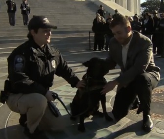 Spike sits with Officer Laura Taylor and Marine Jared Heine.