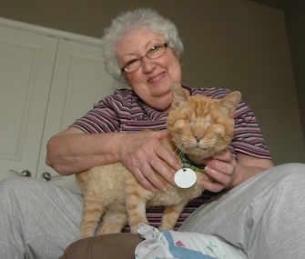 Ranger, who's blind and has feline leukemia, sits with Janet Bushey at their Texas home.