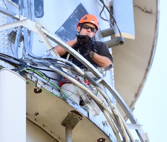 Brady Thomas of the Greeley Fire Department holds on tight to the cat after successfully rescuing him from atop of a water tower.