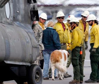 A flood victim and her dog are helped off of a helicopter at the Boulder Municipal Airport in Colorado after being rescued on Monday.