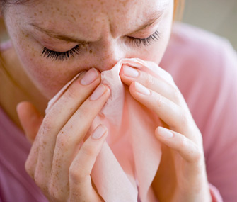 Woman blowing nose