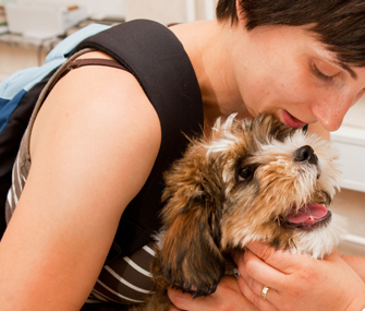 College student petting puppy