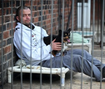 Sean Le Vegan sits in an outdoor day kennel at the Manchester Dogs Home.