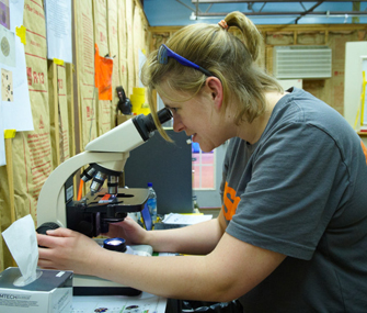 student using a microscope