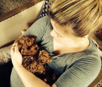 Mom-to-be cuddles her new puppy, Wyatt, on her belly.