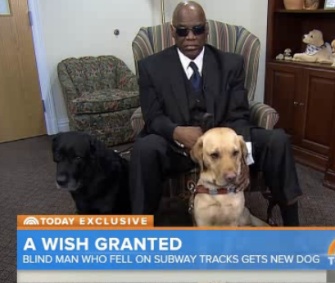 Cecil Williams sits with his retiring guide dog, Orlando, left, and his new dog, Godiva, right.