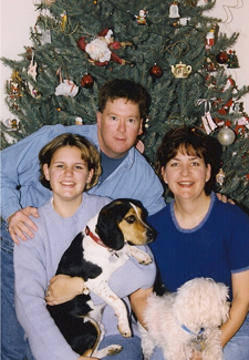 family in front of Christmas tree with Beagle and Maltese