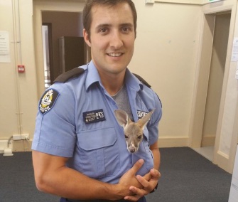 Cuejo cuddles with his hero, Cue, Australia, Police Constable Scott Mason.