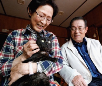 Kazuko, left, and Takeo Yamagishi are reunited with their cat, Suika, in Japan.
