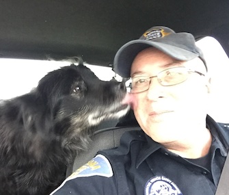 Sadie gives Indiana State Trooper Joe Swisher, a kiss after he rescued her from a busy roadway.