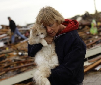 June Simson holds her cat, Sammi, who she found standing on the rubble of her home.