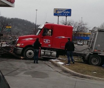The yellow Lab who accidentally kicked a semi truck into gear and crashed looks out the cab window in this photo captured by witness David Stegora.